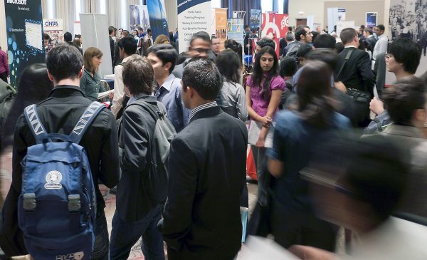 Large crowd of people facing all different directions in business attire at a Career Fair